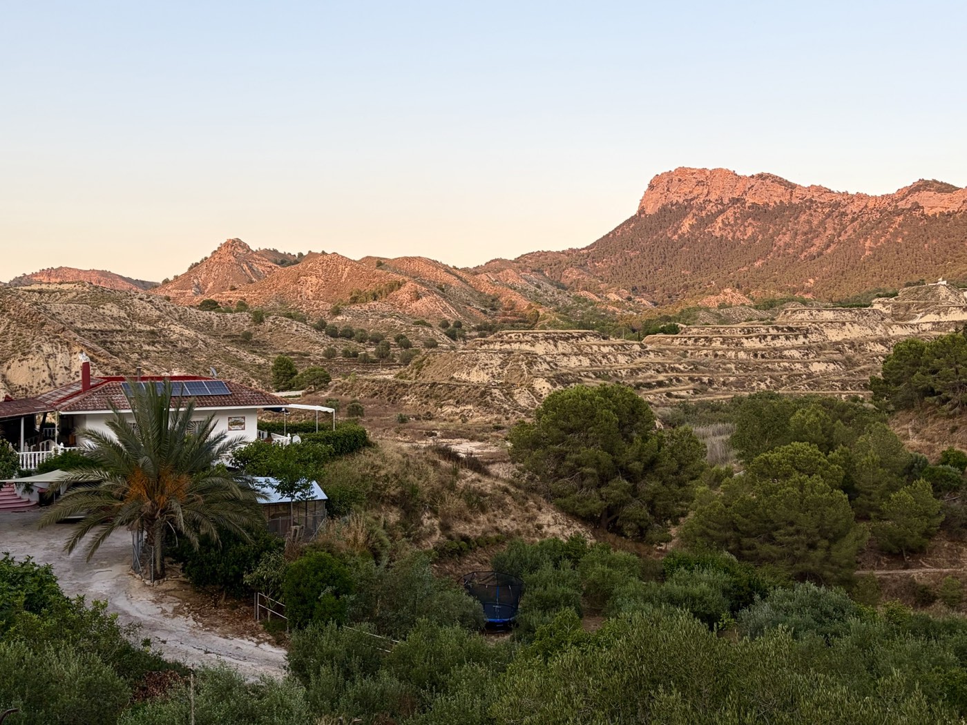 La casa y el paisaje montañoso del Puerto del Garruchal, con bancales y vegetación mediterránea